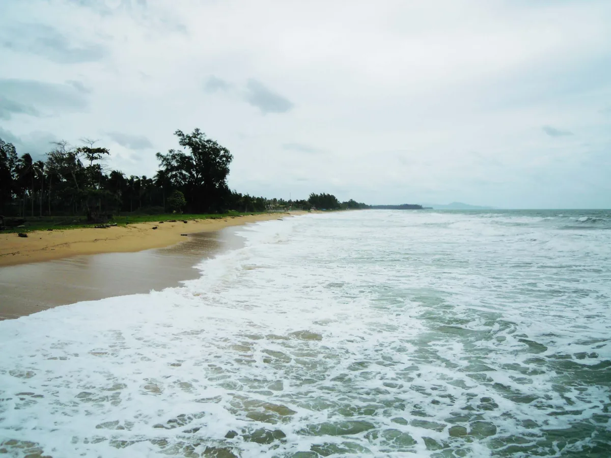 Waves reaching an open sandy stretch of Natai Beach