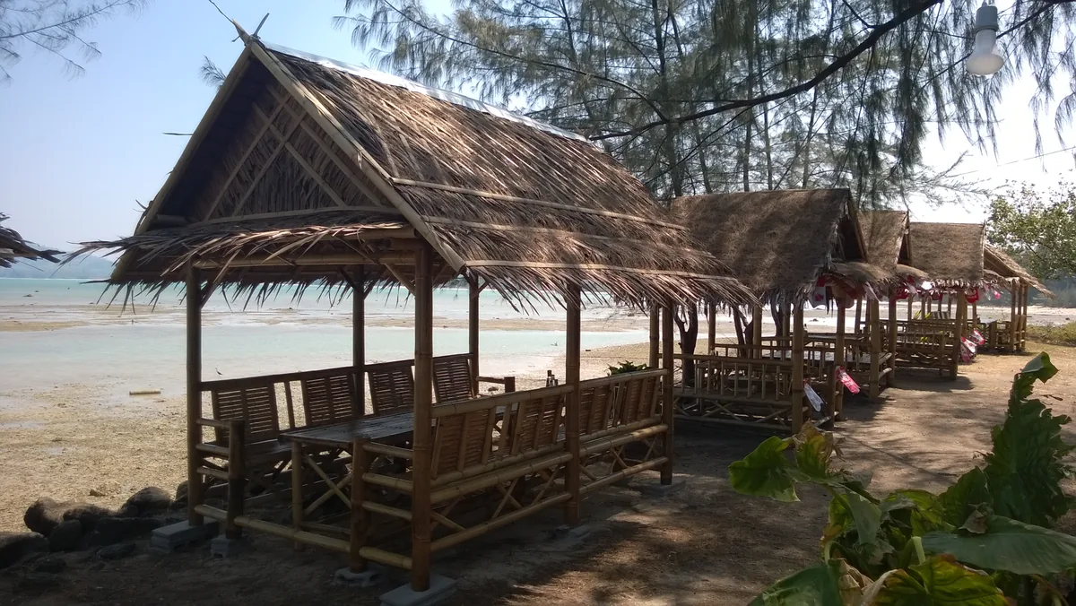 Thatched shelters beside the sand and sea at Pakarang Beach