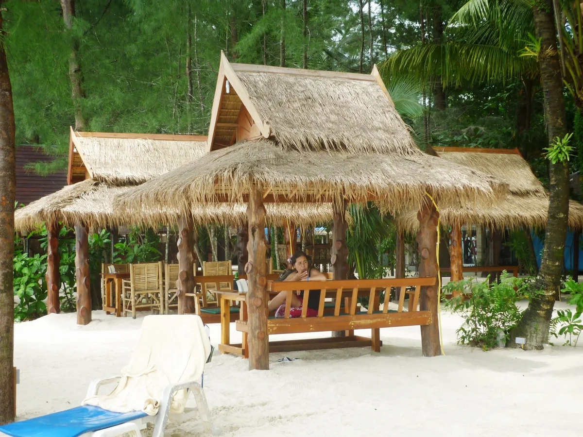 Thatched beach shelters beneath trees on the Khao Lak coast