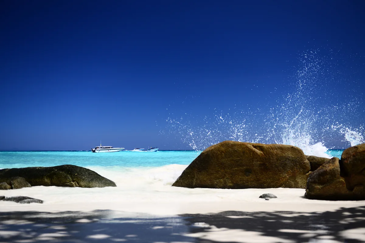 Granite boulders and white sand beside turquoise water in the Similan Islands