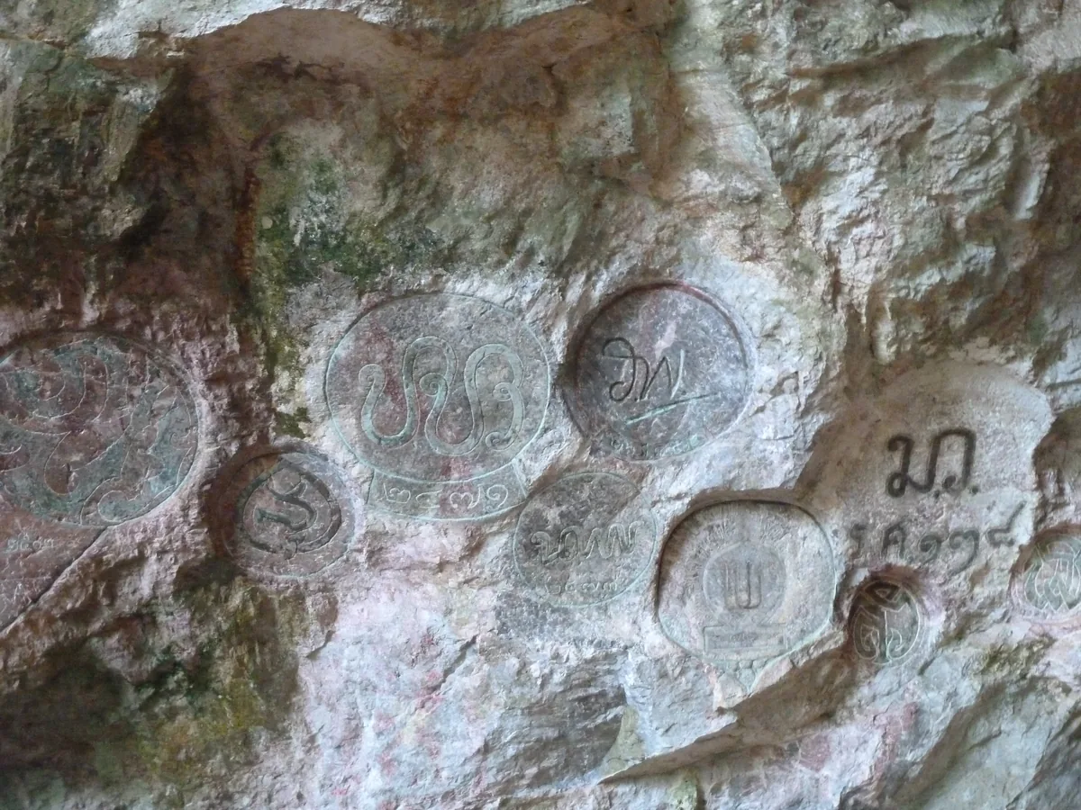 Inscribed symbols on the limestone cave wall at Wat Suwan Khuha