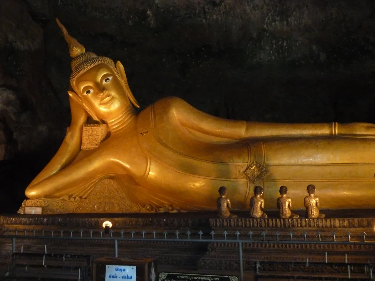 Golden reclining Buddha inside the cave temple at Wat Suwan Khuha