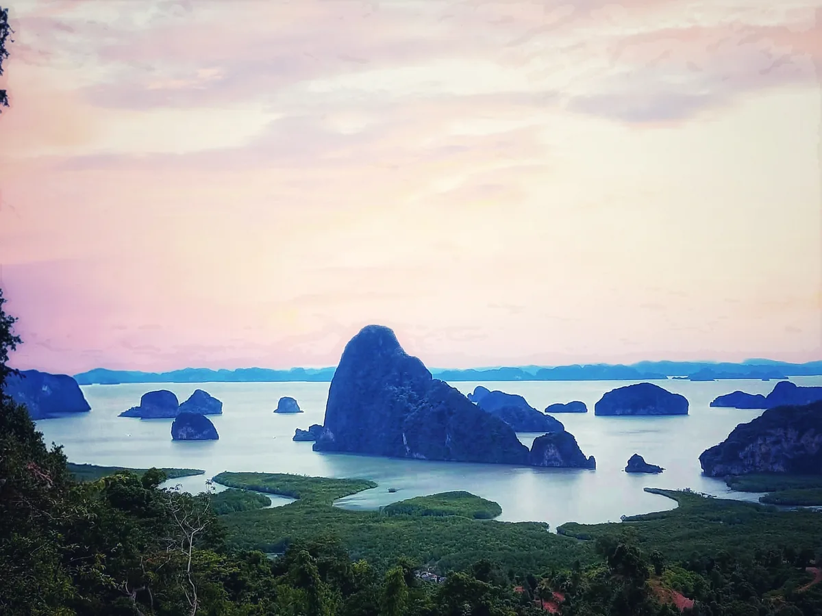 Pink morning sky above limestone islands and mangroves at Samet Nangshe